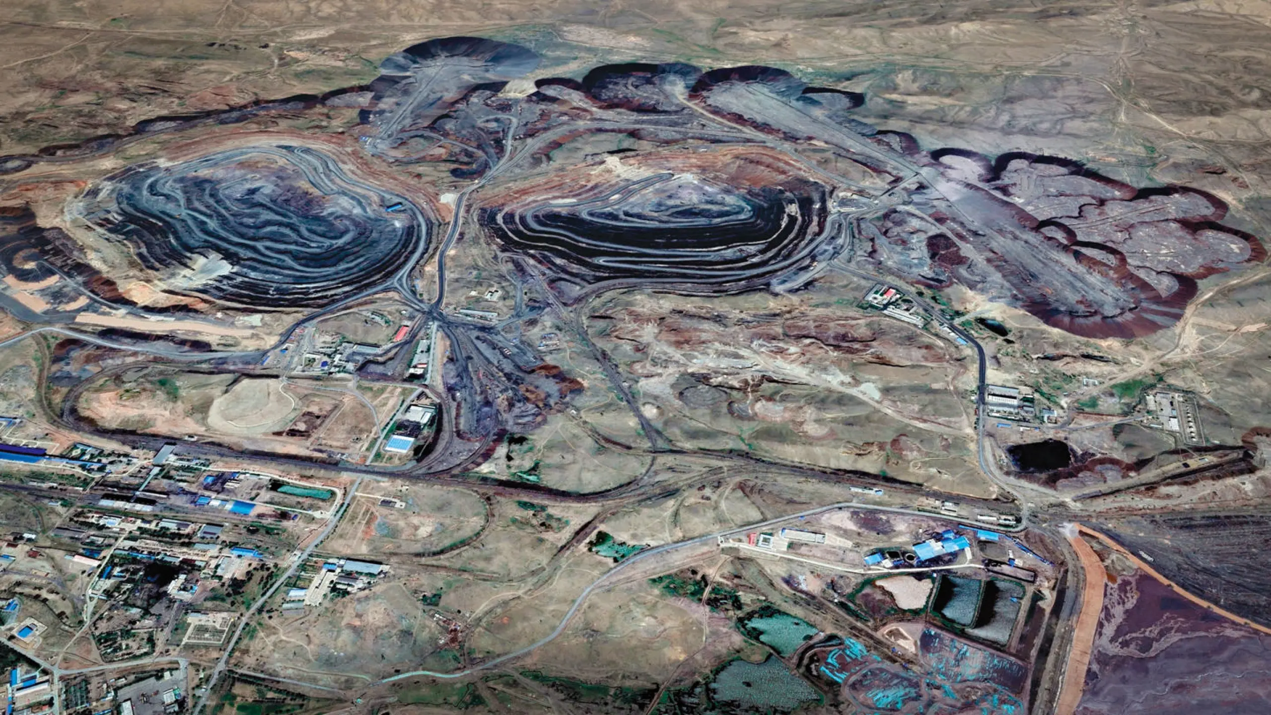 Die Bayan-Obo-Mine im Autonomen Gebiet Innere Mongolei der Volksrepublik China. Sie ist die wichtigste Fund- und Förderstätte der Welt für Seltene Erdmetalle. Im Tagebau arbeiten bis zu 6000 Menschen.