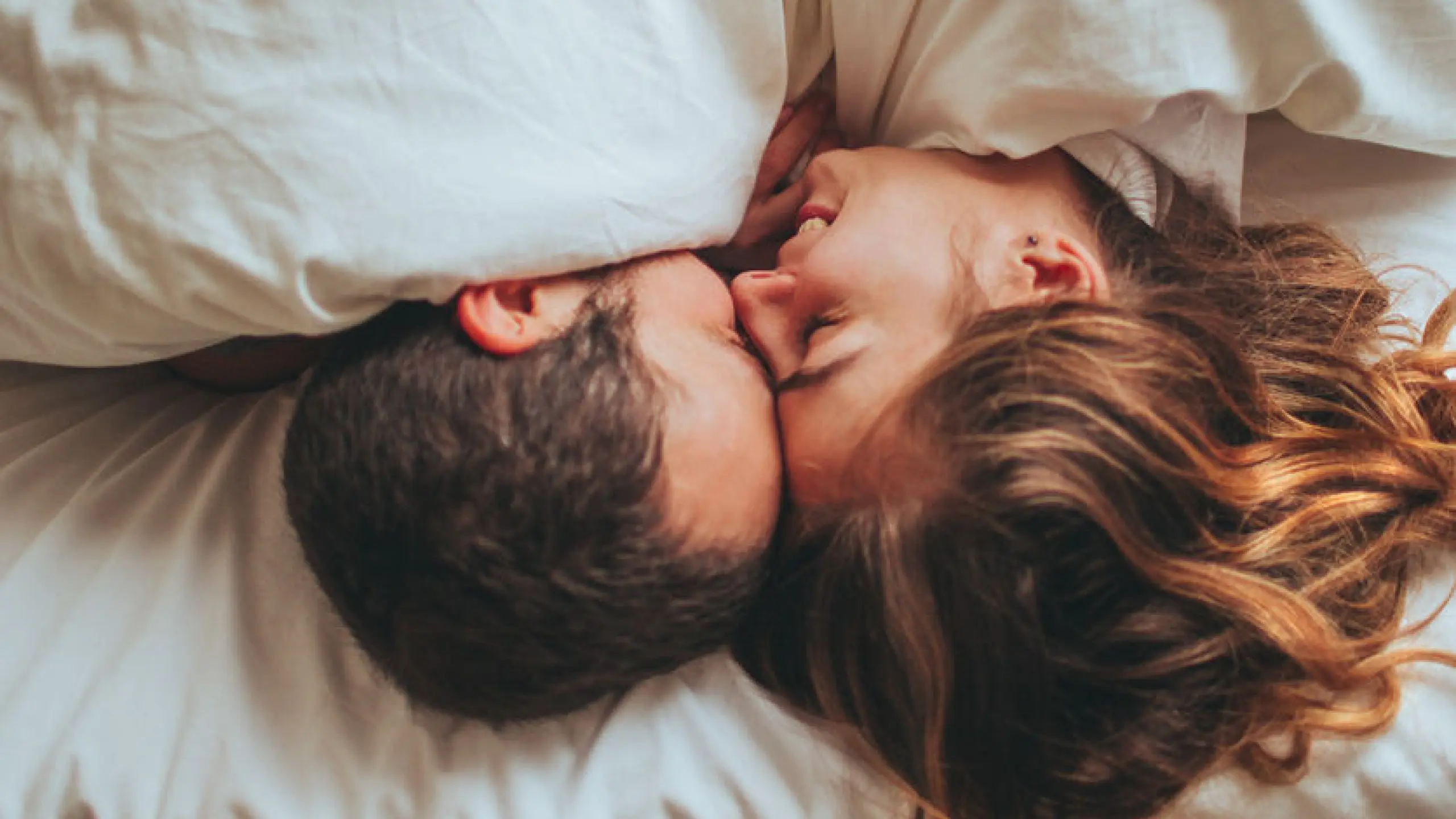 Frau und Mann, die im Bett kuscheln