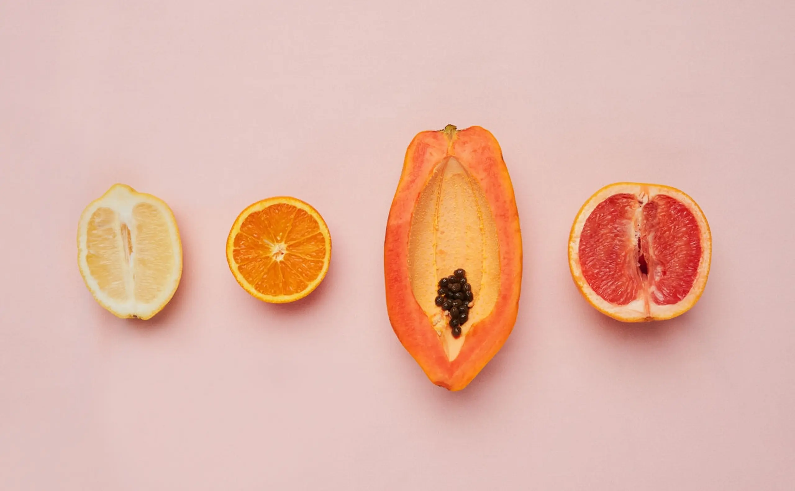 Aufgeschnittene Früchte auf einem rosa Hintergrund