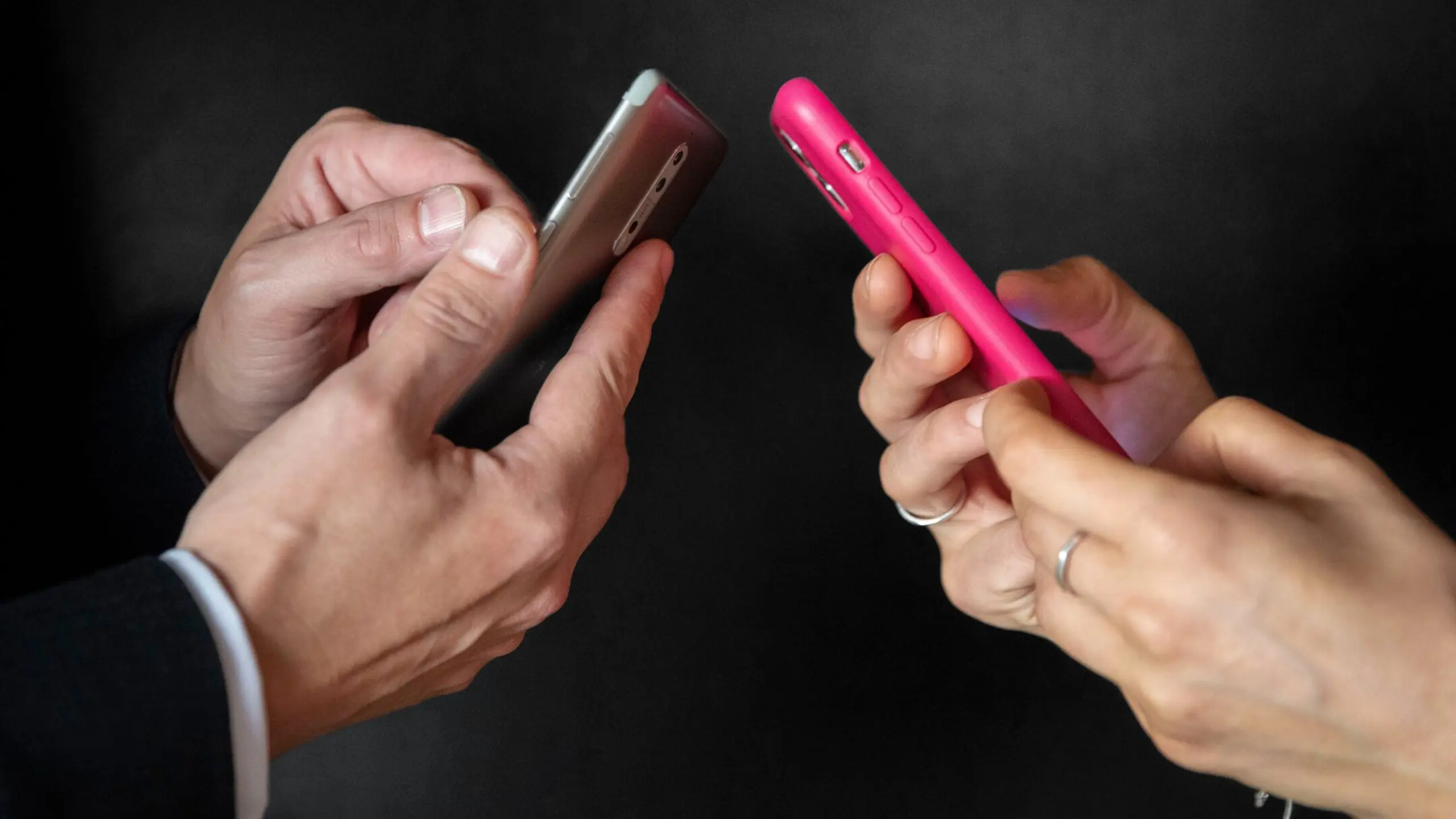 die Hände von zwei Personen am Smartphone