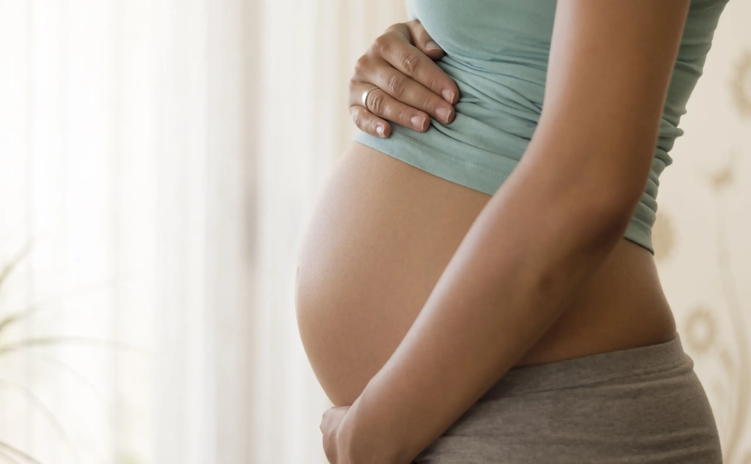 Schwangerschaft: Eine Frau ist schwanger hält sich den Bauch.